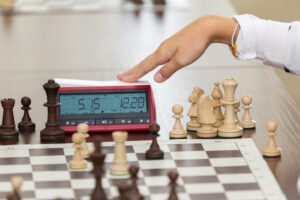 Chess tournament with digital chess clock on wooden table